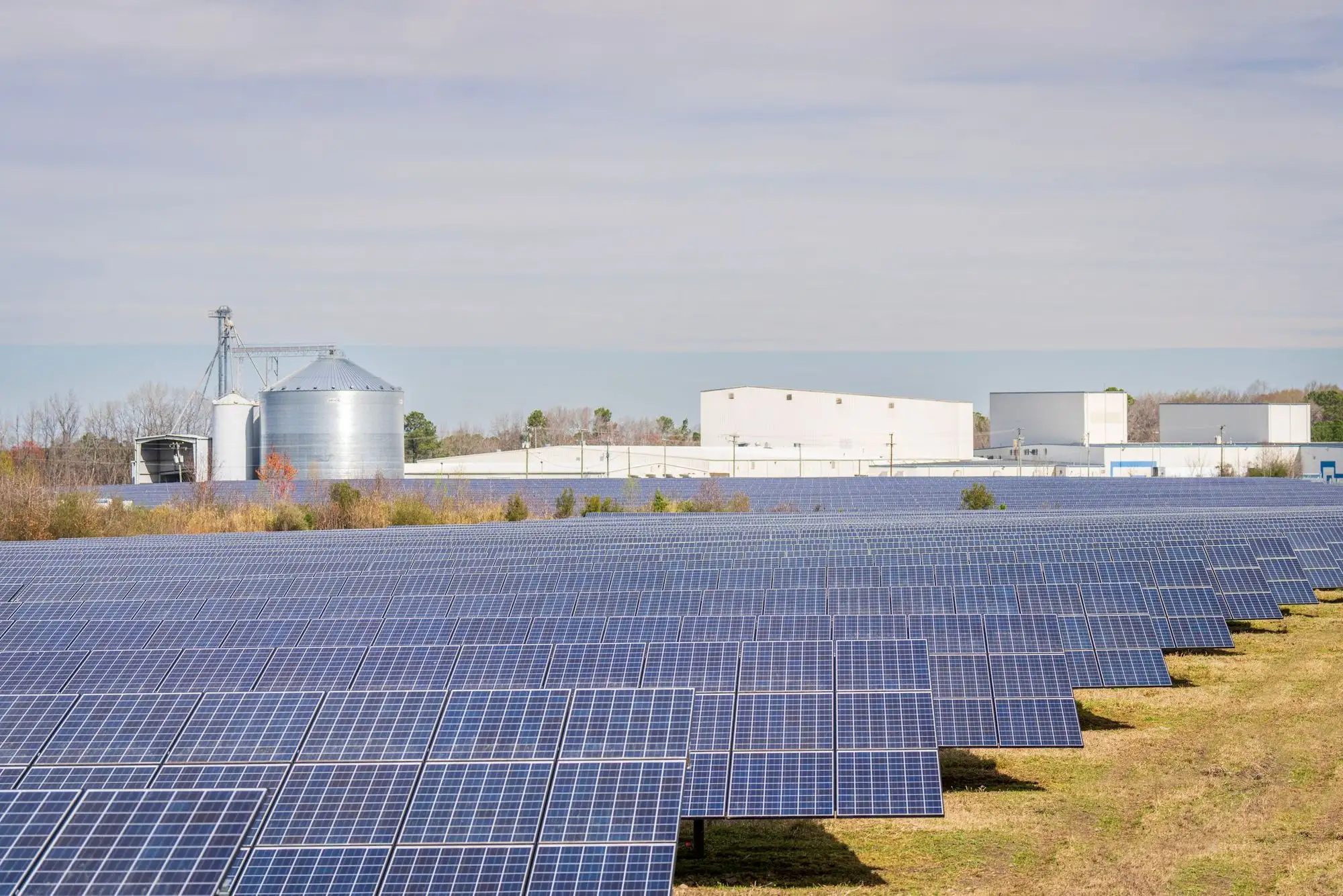 Solar farm beside grain silos and farm buildings
