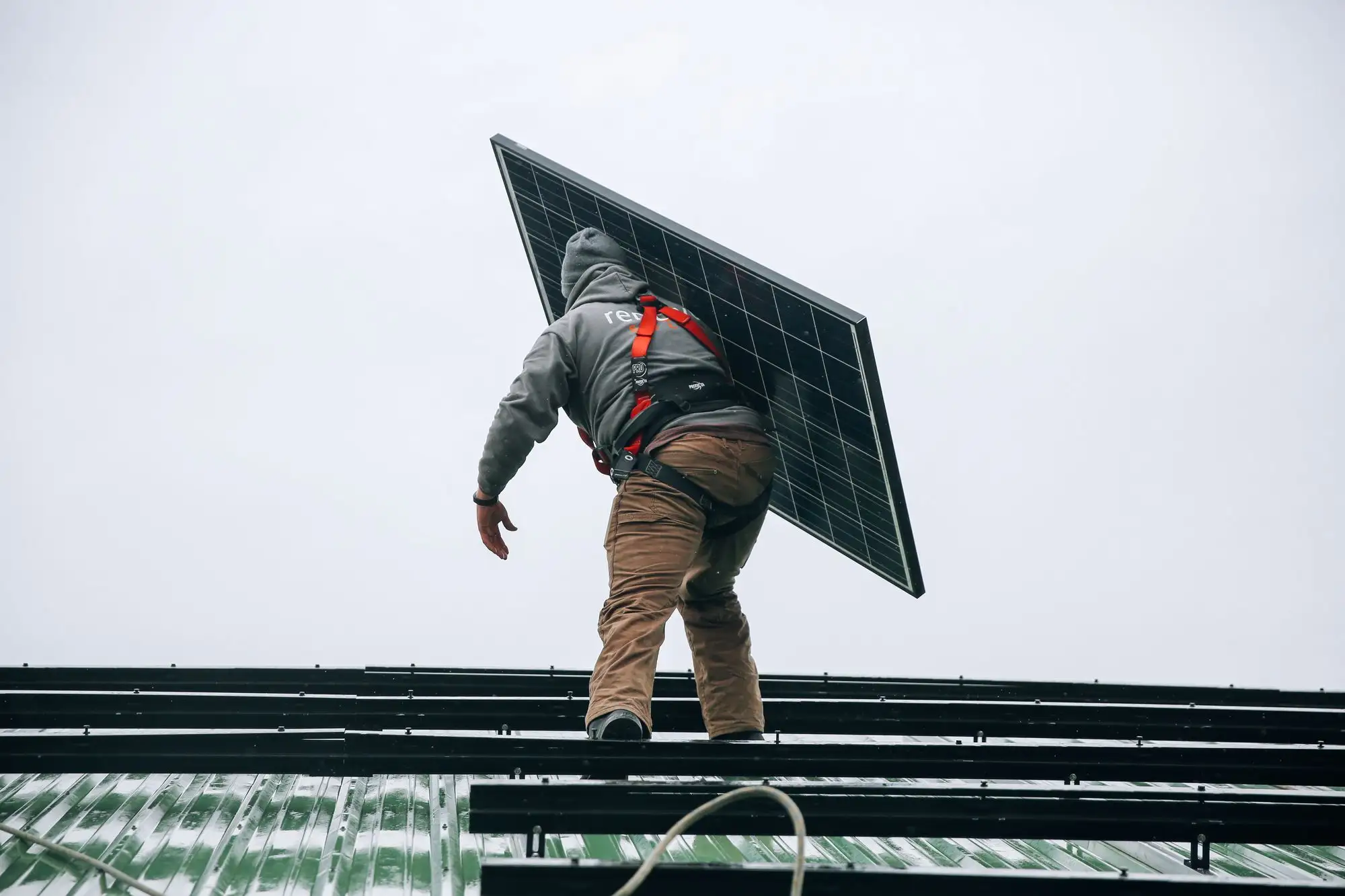 Installer fixing panels to a metal roof